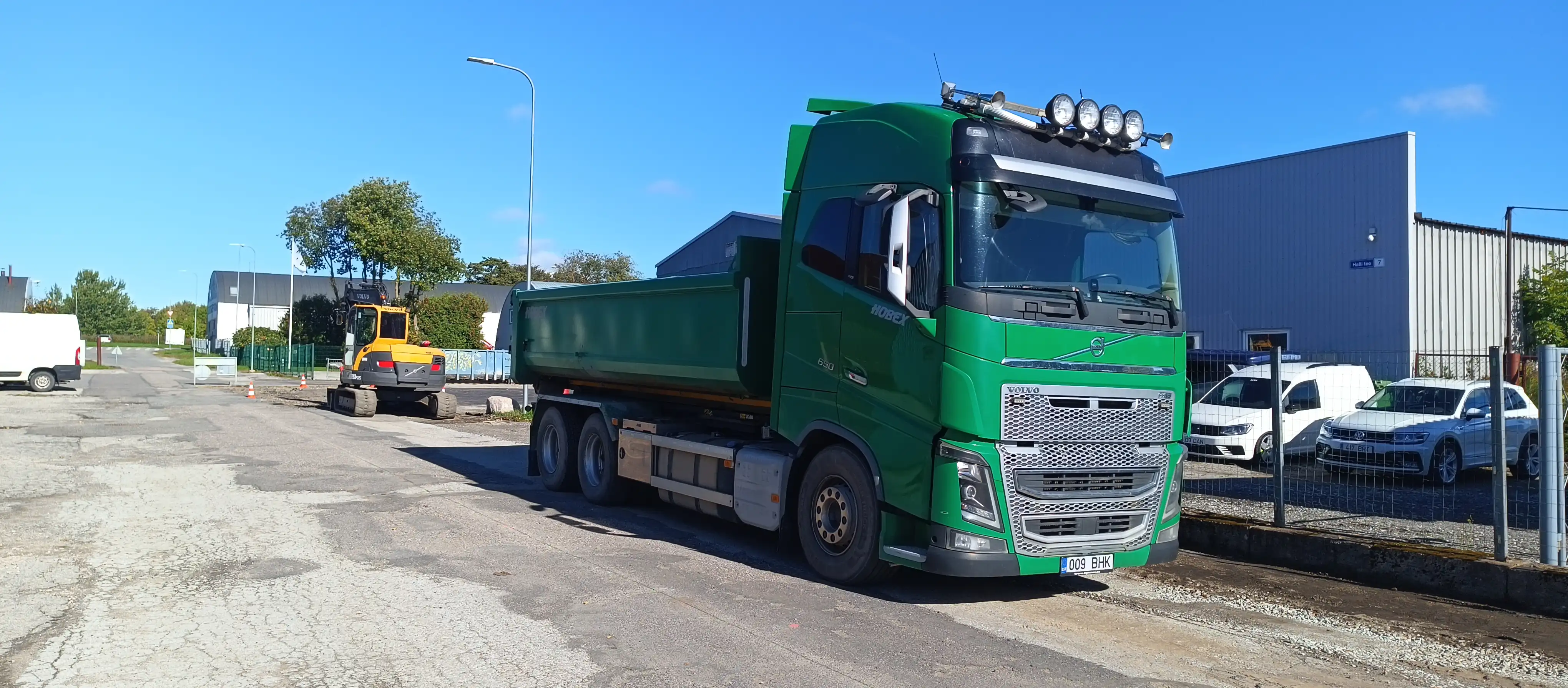 Hobexi roheline Volvo kallur ja ekskavaator tööobjektil